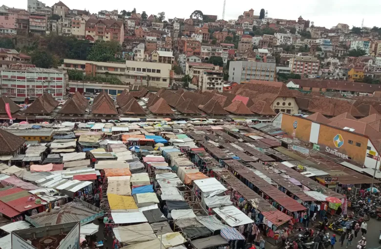 Rows of corrugated market stalls filling the Analakely district of Antananarivo, seen from the slope above.