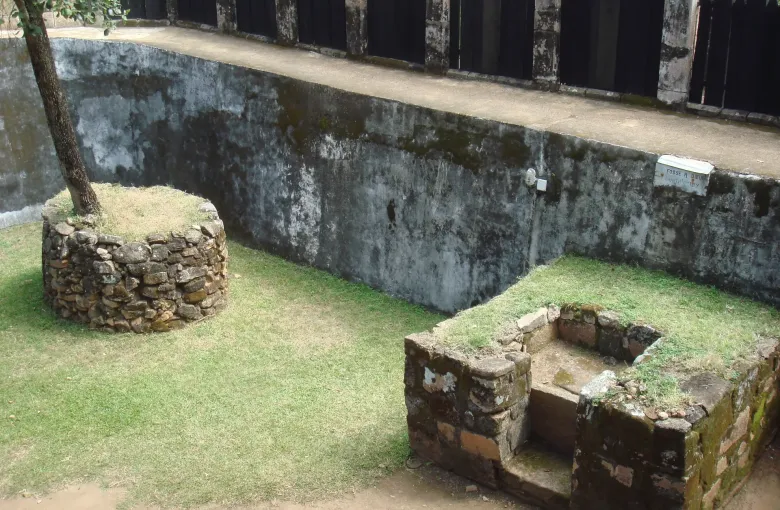 A stone enclosure and dark timber palisade inside the royal compound on the Royal Hill of Ambohimanga near Antananarivo.