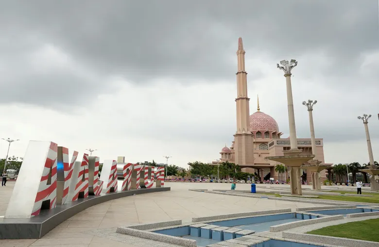 The pink dome and minaret of Putra Mosque seen across Putra Square in Putrajaya, Malaysia.