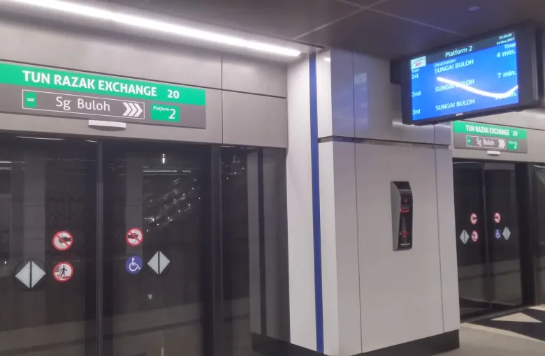 Platform screen doors and wayfinding signs at Tun Razak Exchange MRT station in Kuala Lumpur.