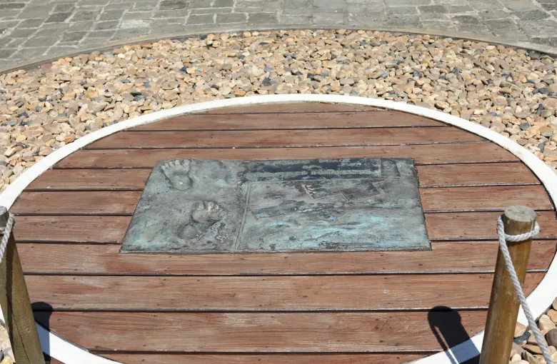 A commemorative stone set into a circular timber deck in the grounds of Aapravasi Ghat, Port Louis.