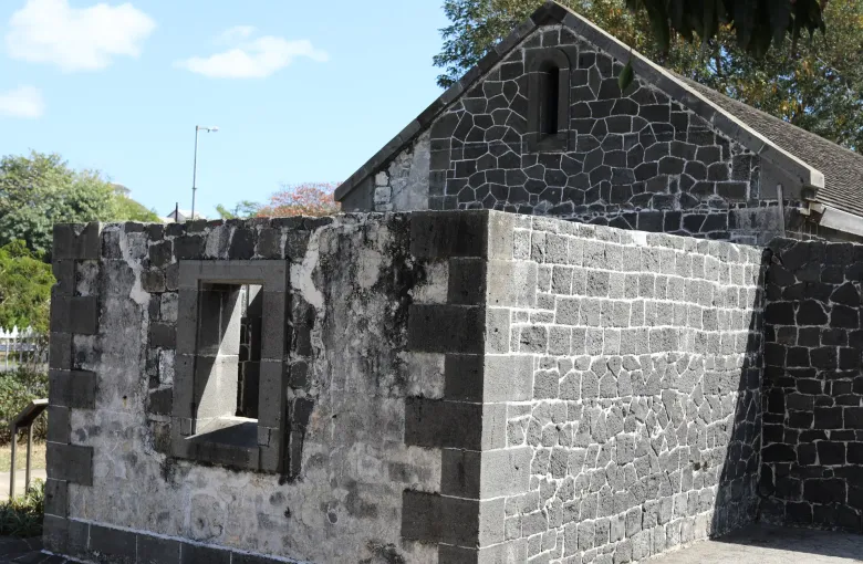 Basalt block walls and a stone building surviving from the immigration depot at Aapravasi Ghat in Port Louis, Mauritius.