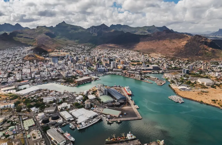 The city of Port Louis and its working harbor seen from above, the Moka range rising behind.