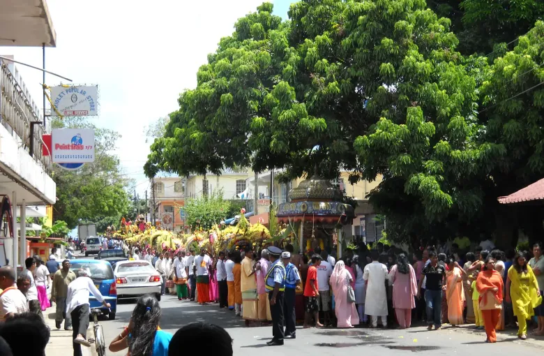 A Thaipoosam Cavadee street procession in Mauritius, a decorated kavadi carried along a road lined with onlookers.