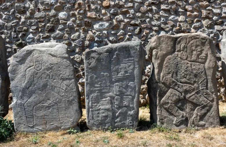 Carved stone slabs of the Danzantes group standing along a wall at Monte Alban above the Oaxaca valley.