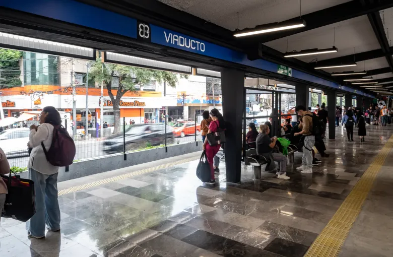 The open-air platform at Viaducto station on Line 2 of the Mexico City Metro with passengers waiting under the canopy.