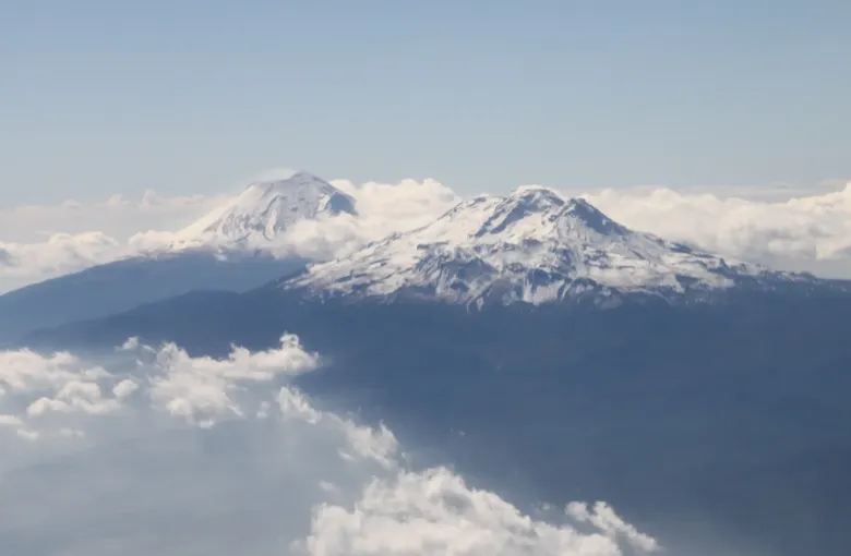 The snow-covered summits of Popocatepetl and Iztaccihuatl standing above a level layer of cloud.