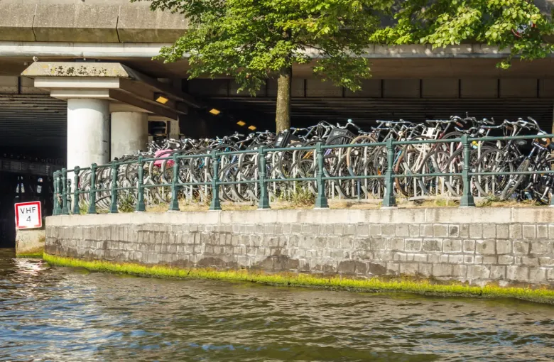 Hundreds of bicycles racked along a multi-level parking deck built out over the water at Amsterdam's Stationsplein.