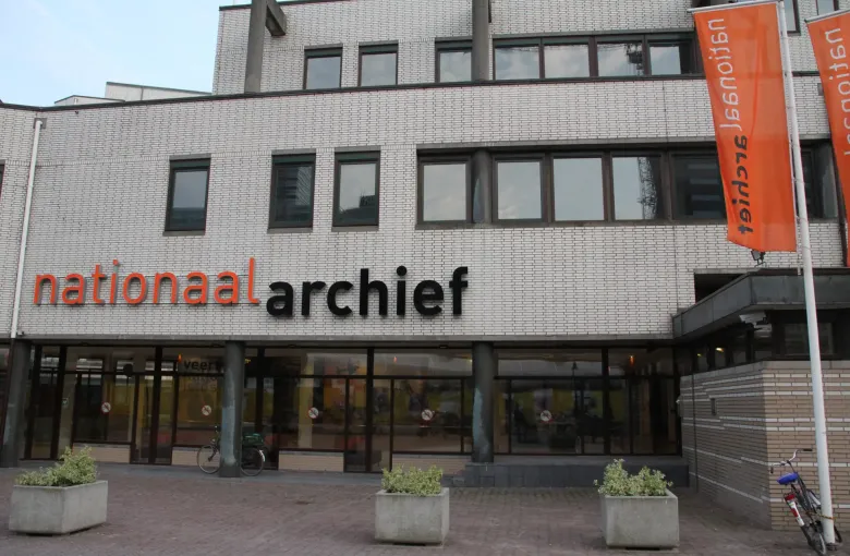 The entrance of the Nationaal Archief in The Hague, its name across the facade and orange banners beside the doors.