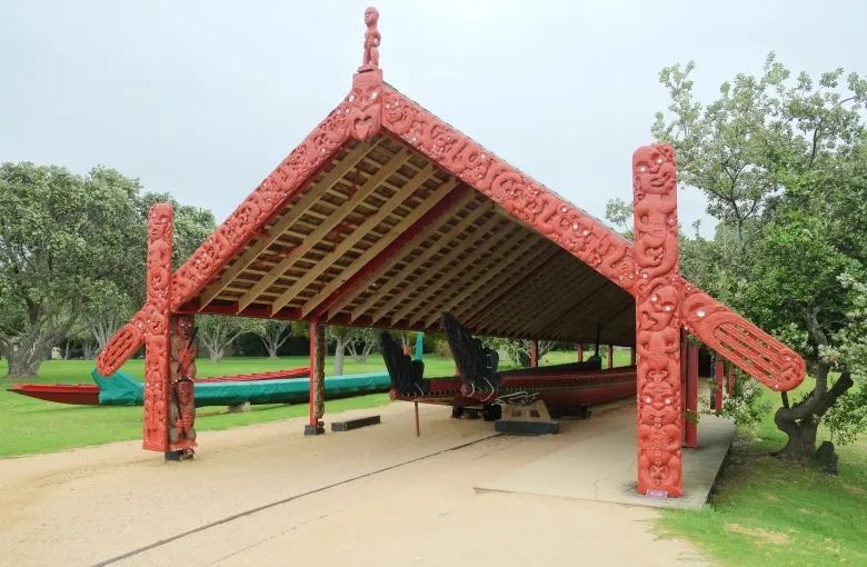 The ceremonial waka Ngatokimatawhaorua under its carved open shelter at the Waitangi Treaty Grounds.