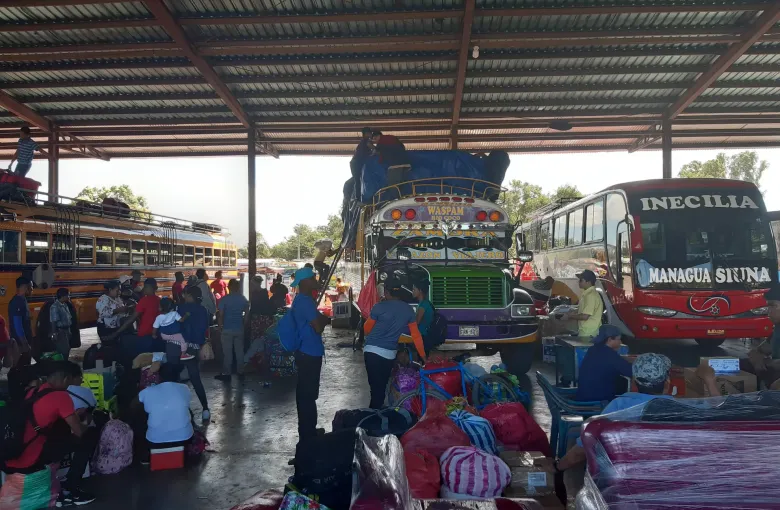 Passengers, freight and repurposed school buses fill a covered intercity bus terminal in Managua.