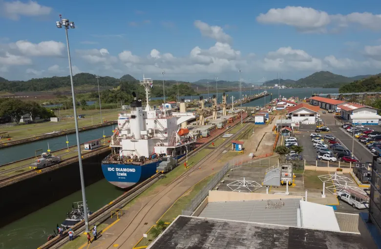 A cargo ship in the Miraflores lock chamber seen from the visitor center viewing deck above.