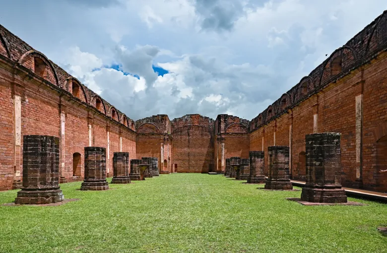 The trilobed Moorish arches of the unfinished mission church at Jesus de Tavarangue frame an open sky.
