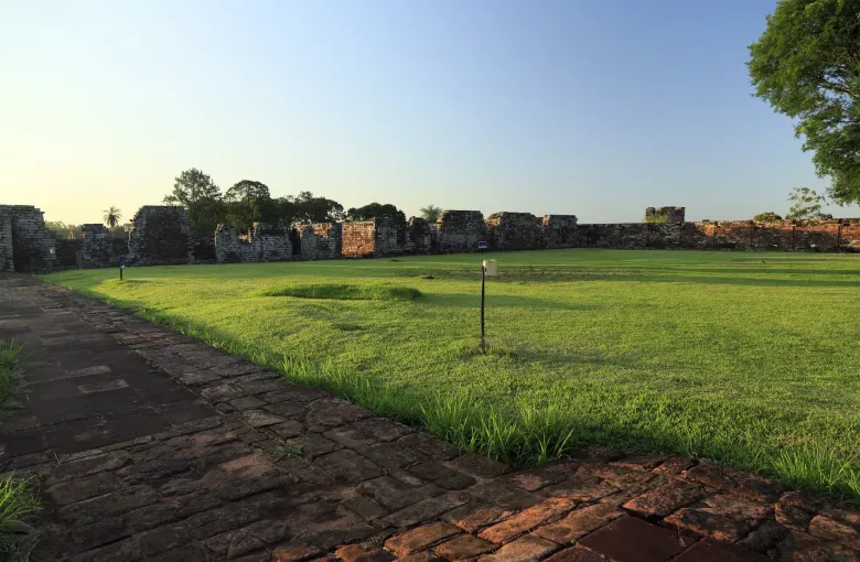 Level brick paths run beside close cut lawn along the low perimeter walls of the patio at Trinidad.