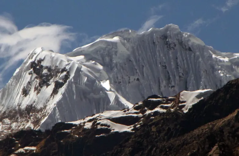 A snow and ice summit in the Cordillera Blanca above Huaraz with cloud streaming off the ridge.