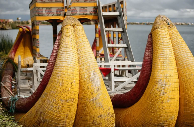 The curved prows of totora reed boats moored at the Uros floating islands on Lake Titicaca.