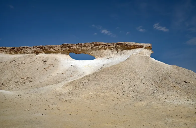 Wind eroded limestone rising from flat desert on the Zekreet peninsula in western Qatar