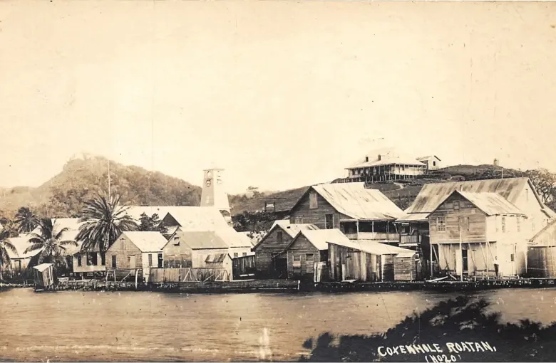 A sepia photograph of the timber waterfront of Coxen Hole in the early twentieth century.