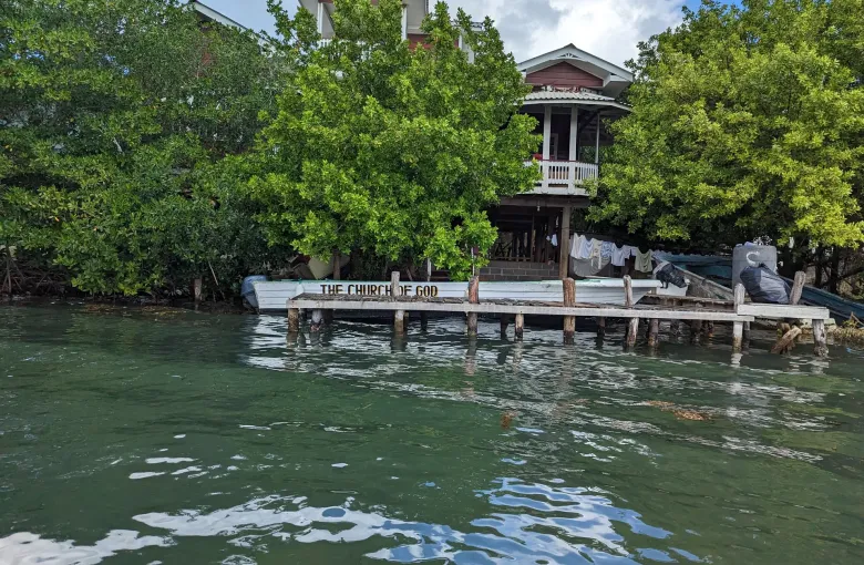 A timber building and a moored boat at the mangrove edge of Oak Ridge.
