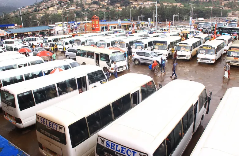 Minibuses and intercity coaches filling Nyabugogo bus park in Kigali, Rwanda, after rain.