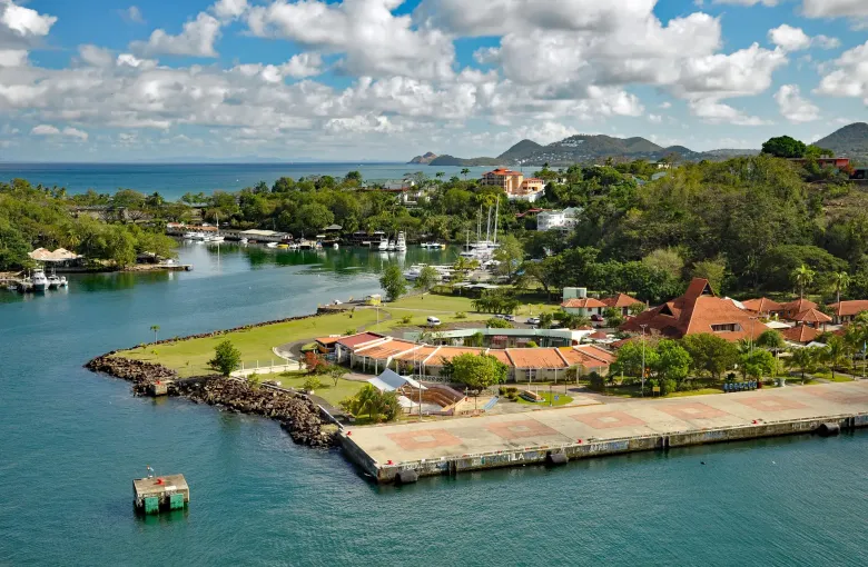 Boats moored in Castries harbor below red-roofed buildings in Saint Lucia.