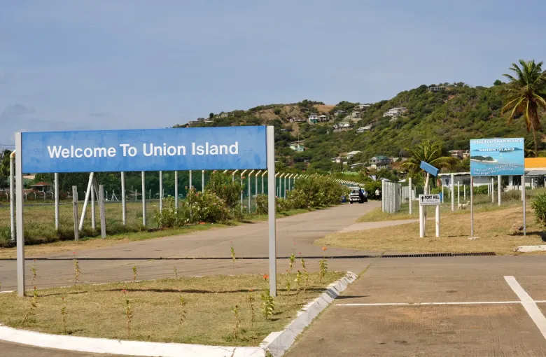 The road in from the airstrip on Union Island, with houses on the hillside beyond.