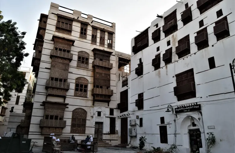 People sitting outside a shop in the coral-stone lanes of Al-Balad, the old quarter of Jeddah, Saudi Arabia.