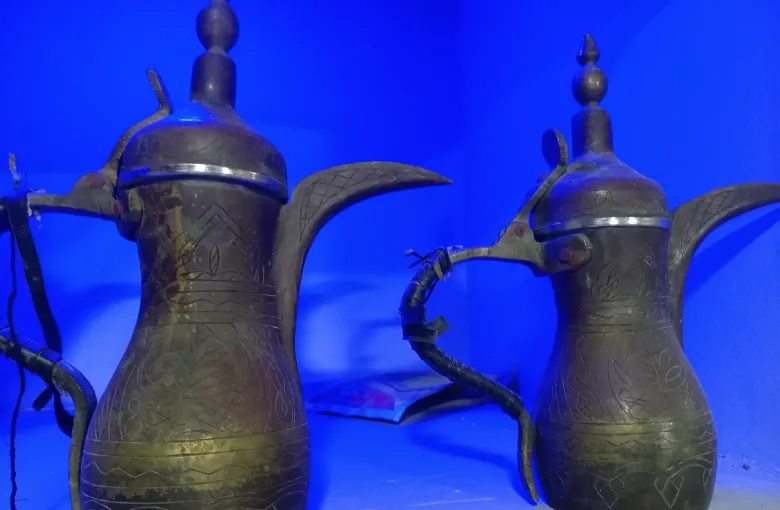 Two engraved copper dallah coffee pots of the kind used to serve Arabic coffee across the Arabian Peninsula.