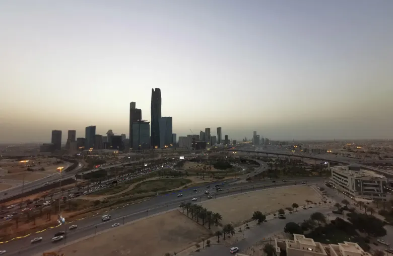 The towers of the King Abdullah Financial District in Riyadh, Saudi Arabia, seen across the ring road at dusk.