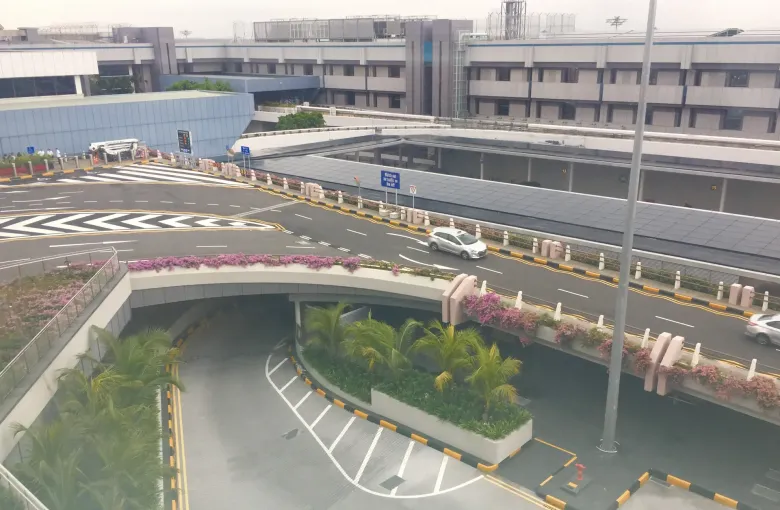 A curving approach road and covered set-down area at Terminal 1 of Singapore Changi Airport.