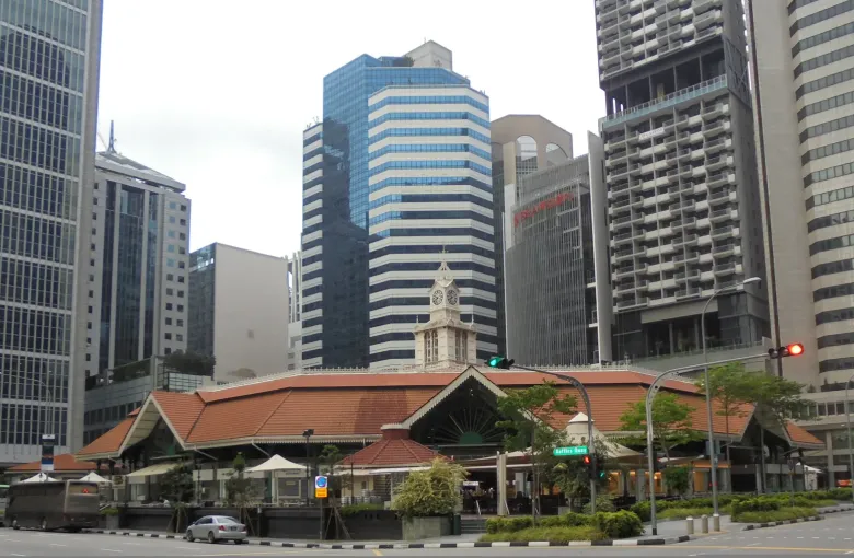 The cast iron Victorian market hall of Lau Pa Sat in Singapore, with the towers of the financial district behind it.