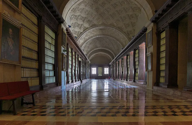 A vaulted gallery in the Archivo General de Indias in Seville, Spain, lined with cases of bound colonial records.