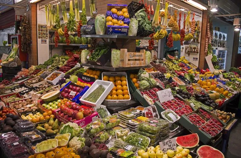 Fruit and vegetables banked up on a stall at the Mercado de Triana in Seville, Spain, with hand written price cards.