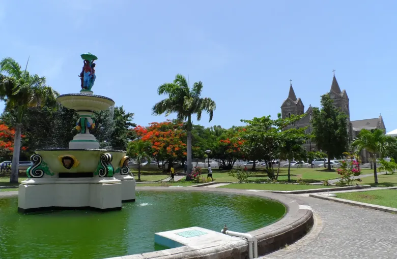 The painted fountain in Independence Square, Basseterre, with the twin-towered co-cathedral beyond.