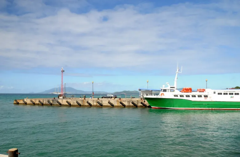 A green and white St Kitts to Nevis passenger ferry moored at the Charlestown dock on Nevis.