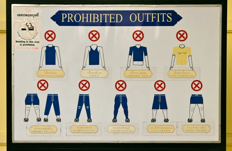 A sign headed Prohibited Outfits at the Grand Palace, showing crossed-out vests, short tops and short trousers.