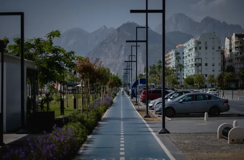A paved cycle and walking path along the coast at Antalya, Turkey, with the Taurus mountains rising behind the town.