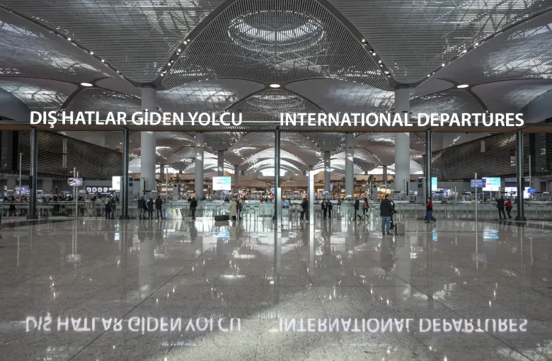 The international departures concourse at Istanbul Airport in Turkey, its vaulted roof above a polished floor and bilingual signage.