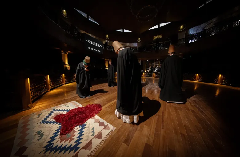 Dervishes in white robes and tall felt hats turning during the sema ceremony in Konya, Turkey.