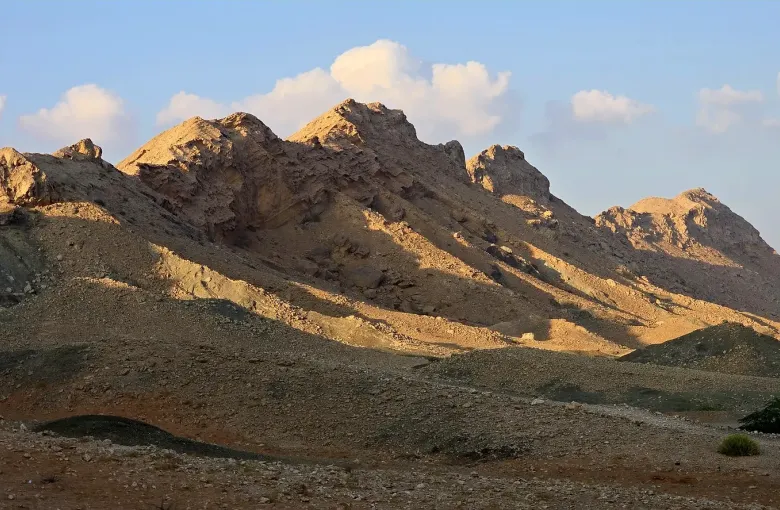 The low rocky ridge of Jebel Faya in Sharjah rising from open gravel desert