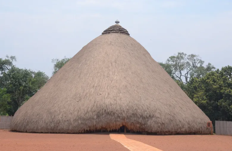 The large domed thatched tomb building at the Tombs of Buganda Kings at Kasubi in Kampala, Uganda, standing on a swept earth apron.