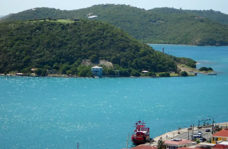 Hassel Island across the water at Charlotte Amalie on St Thomas, a red boat at the quay below.