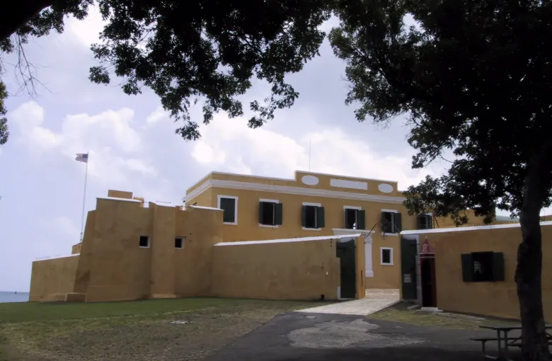 The yellow walls of Fort Christiansvaern at Christiansted on St Croix, seen across its open lawn.