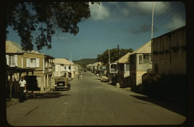 A street of wooden and masonry buildings in Frederiksted on St Croix, photographed in color in 1941.