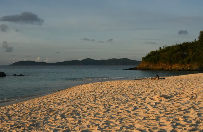 The sand at Trunk Bay on St John at dusk, the headlands of the national park dark against the water.