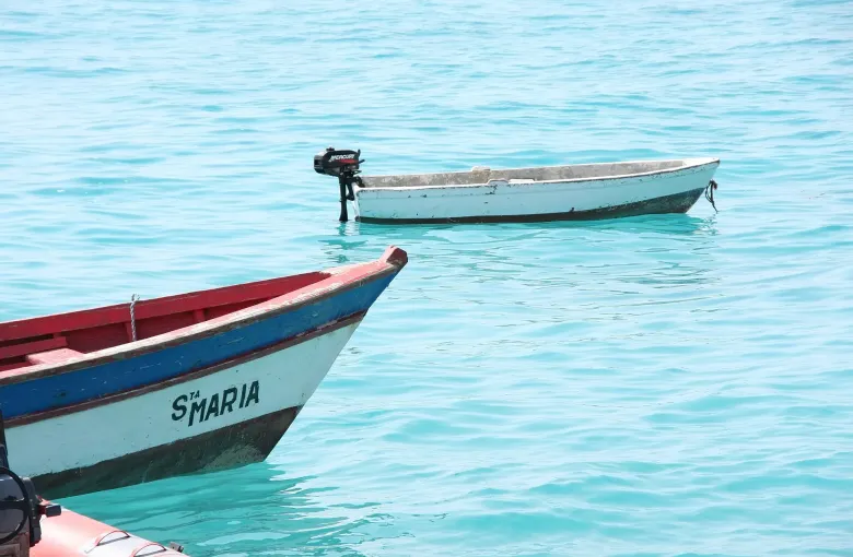 Two painted fishing boats on clear turquoise water off Santa Maria on the island of Sal.