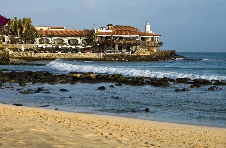 A tiled-roof restaurant terrace above the rocks and sand at Santa Maria on Sal.