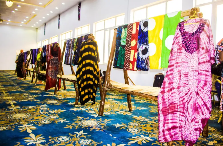 Racks of Yoruba adire resist-dyed cloth and finished garments on display at a cultural exhibition in Nigeria.