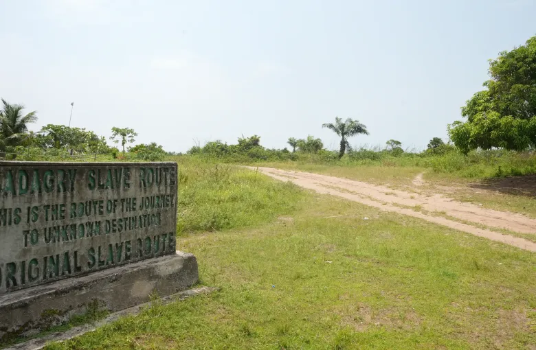 A stone marker beside the sand track at Badagry, Lagos State, Nigeria, reading Badagry Slave Route, this is the route of the journey to unknown destination.